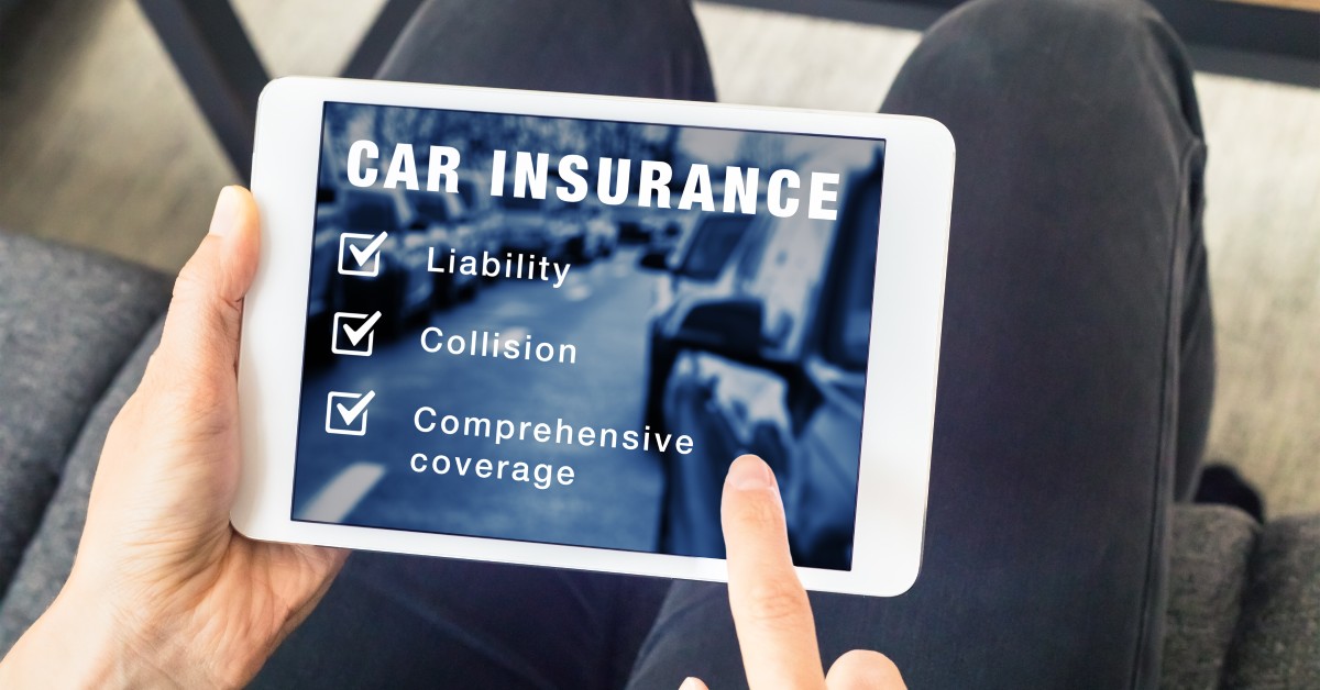 A person sits while holding a tablet, viewing different car insurance types, including liability and comprehensive coverage.